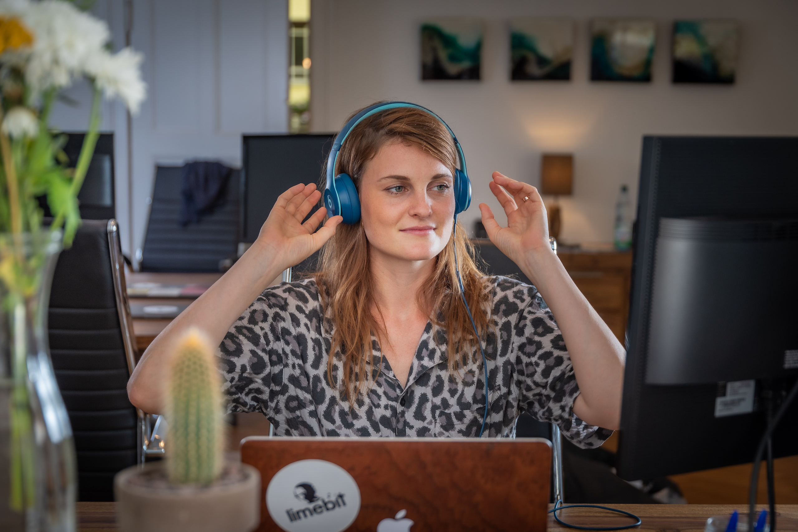 Eine Limebit Mitarbeiterin hört Musik über Ihre Kopfhörer und konzentriert sich dabei
